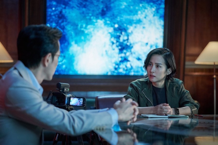 Murderer Report Psychological Thriller Interview Scene Baek Seon-ju (Cho Yeo Jung) and Lee Yeong Hun (Jung Sung Il) sit in a confined hotel suite, facing each other in a psychological thriller scene from “Murderer Report,” highlighting the moral and ethical tension between victim and perpetrator.
